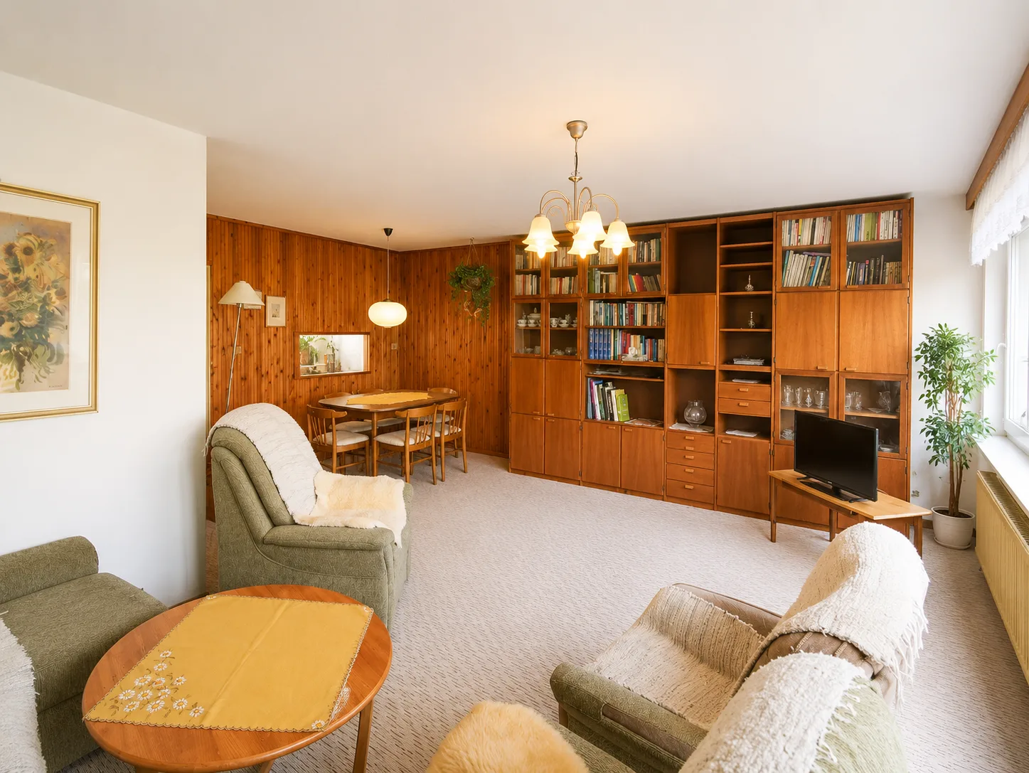Dining area with original 1970s wood panelling and bookcase wall