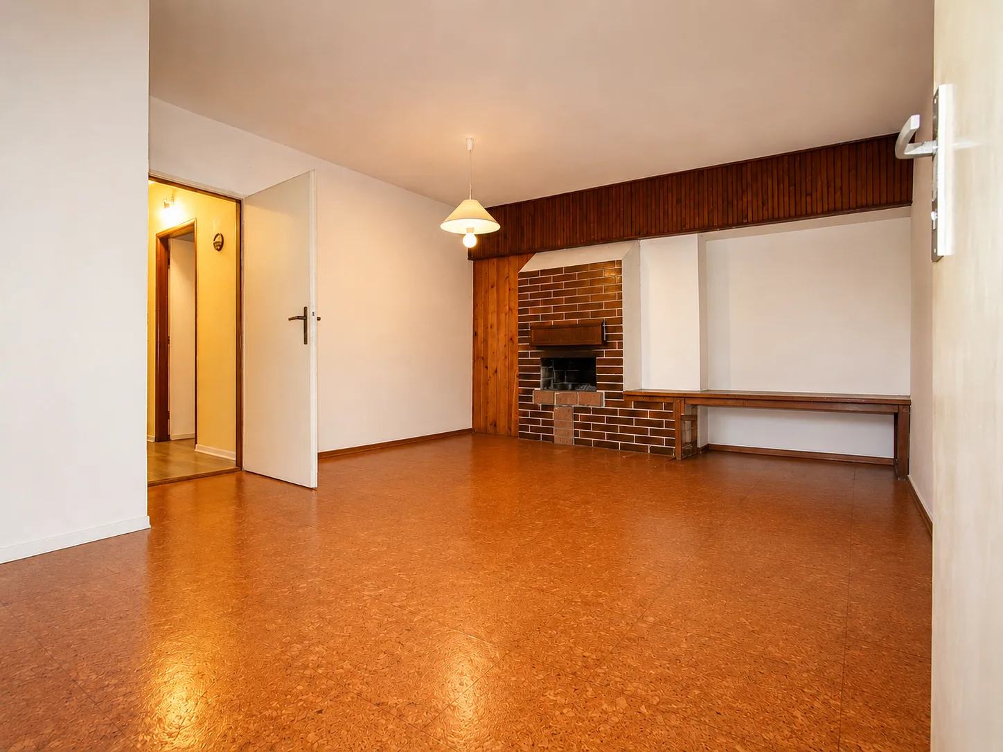 Basement room with brick fireplace and cork floor